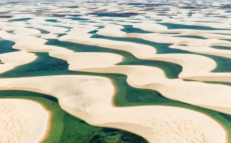 Dunas brancas dos Lençóis Maranhenses com lagoas de água azul-esverdeada entre a areia, no Maranhão