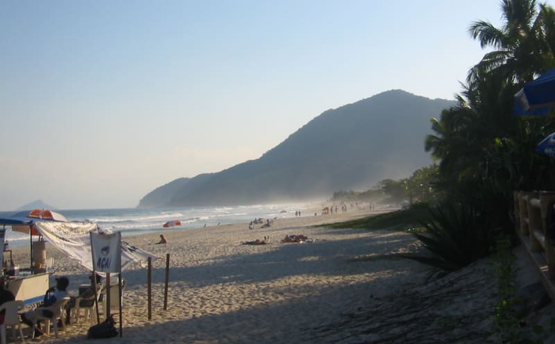 Praia de Maresias ao entardecer, com serra ao fundo, em São Sebastião